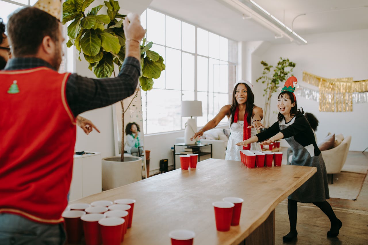 Lively office holiday party featuring a friendly game of beer pong with colleagues.