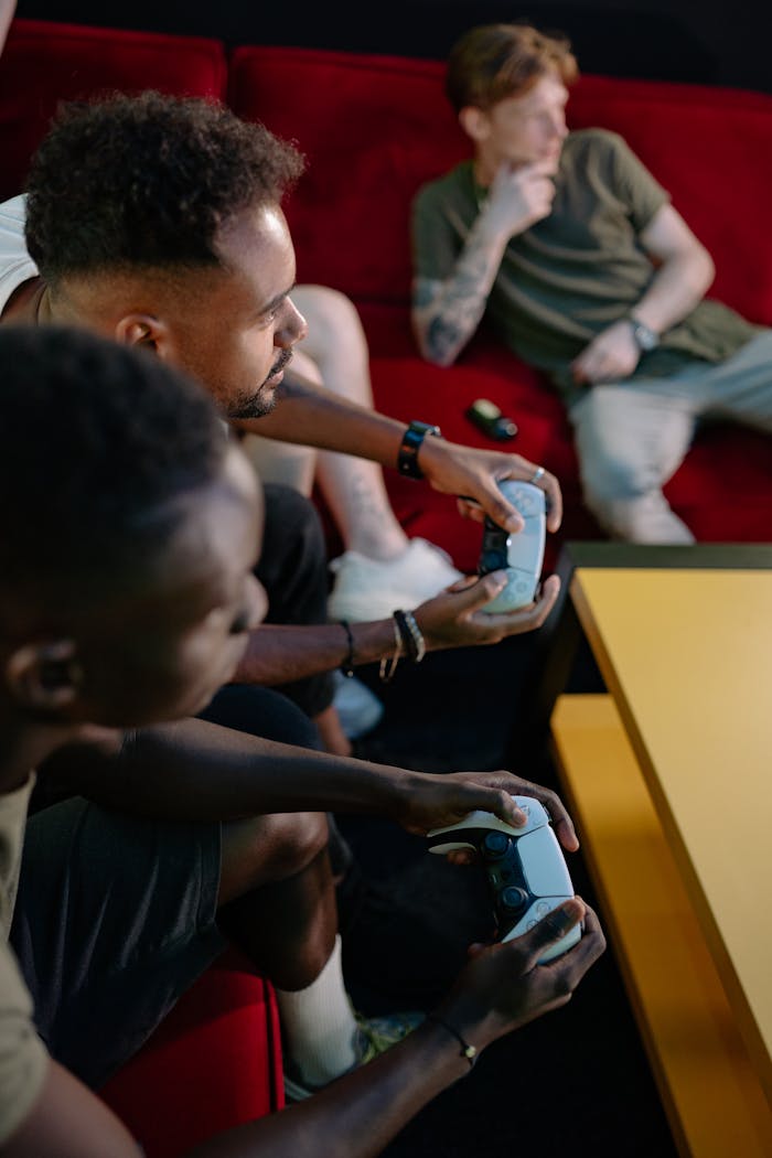 who-are-we-02 Three friends intensely playing video games together in a cozy indoor setup.