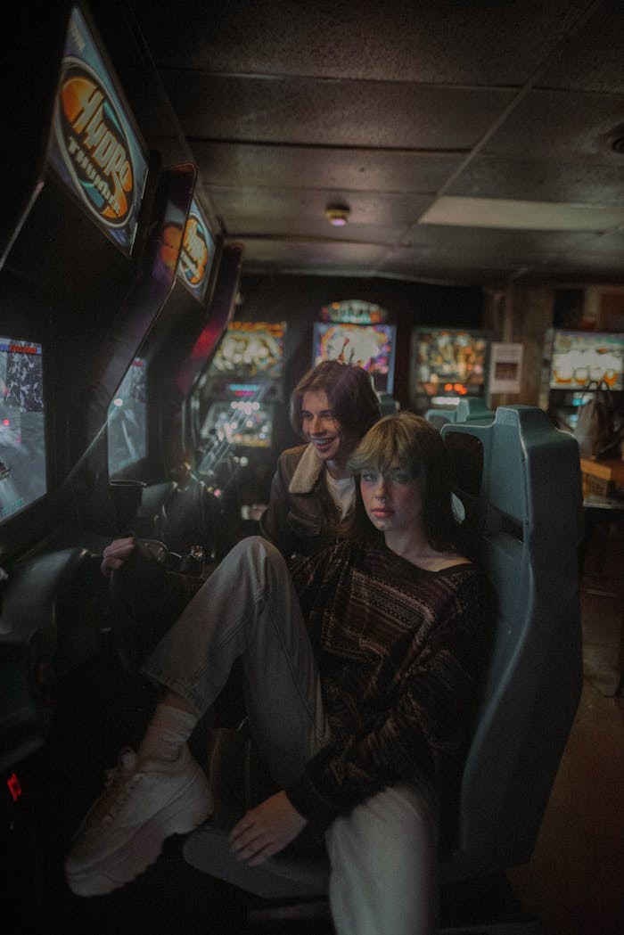 services-01 Two young adults playing video games at an arcade, immersed in entertainment.